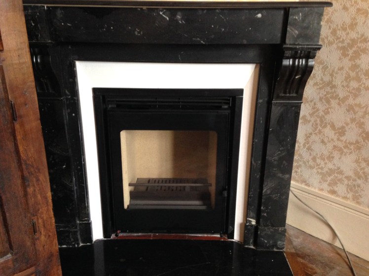 Pose de cheminée ancienne en marbre avec un insert moderne.