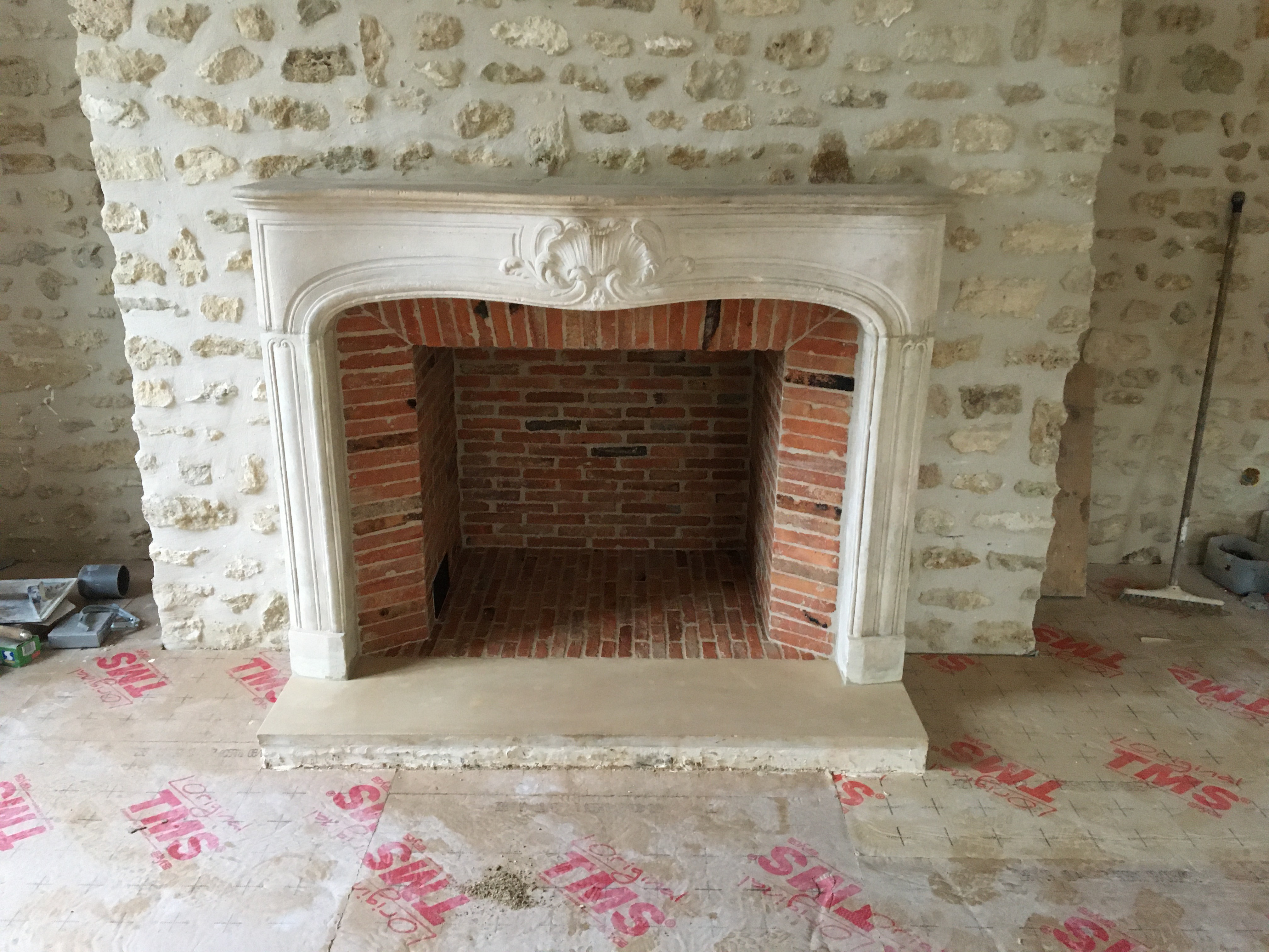 Pose d’une cheminée de style Louis XV en pierre – Le Plaisir du Feu