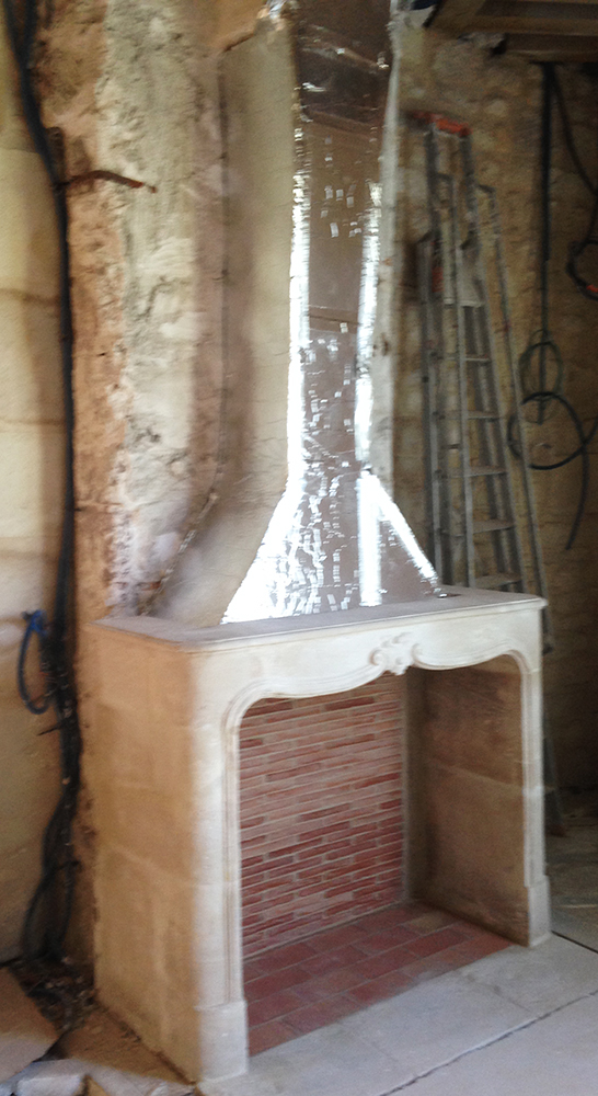 Installation d'une cheminée en pierre Louis XV à Paris.