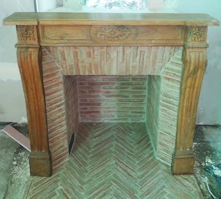 Installation d'une cheminée de style Louis XVI en bois avec intérieur en briquettes réfractaires