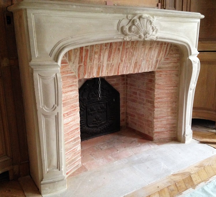 Pose d'une cheminée de style Régence en pierre avec intérieur en briquettes réfractaires.